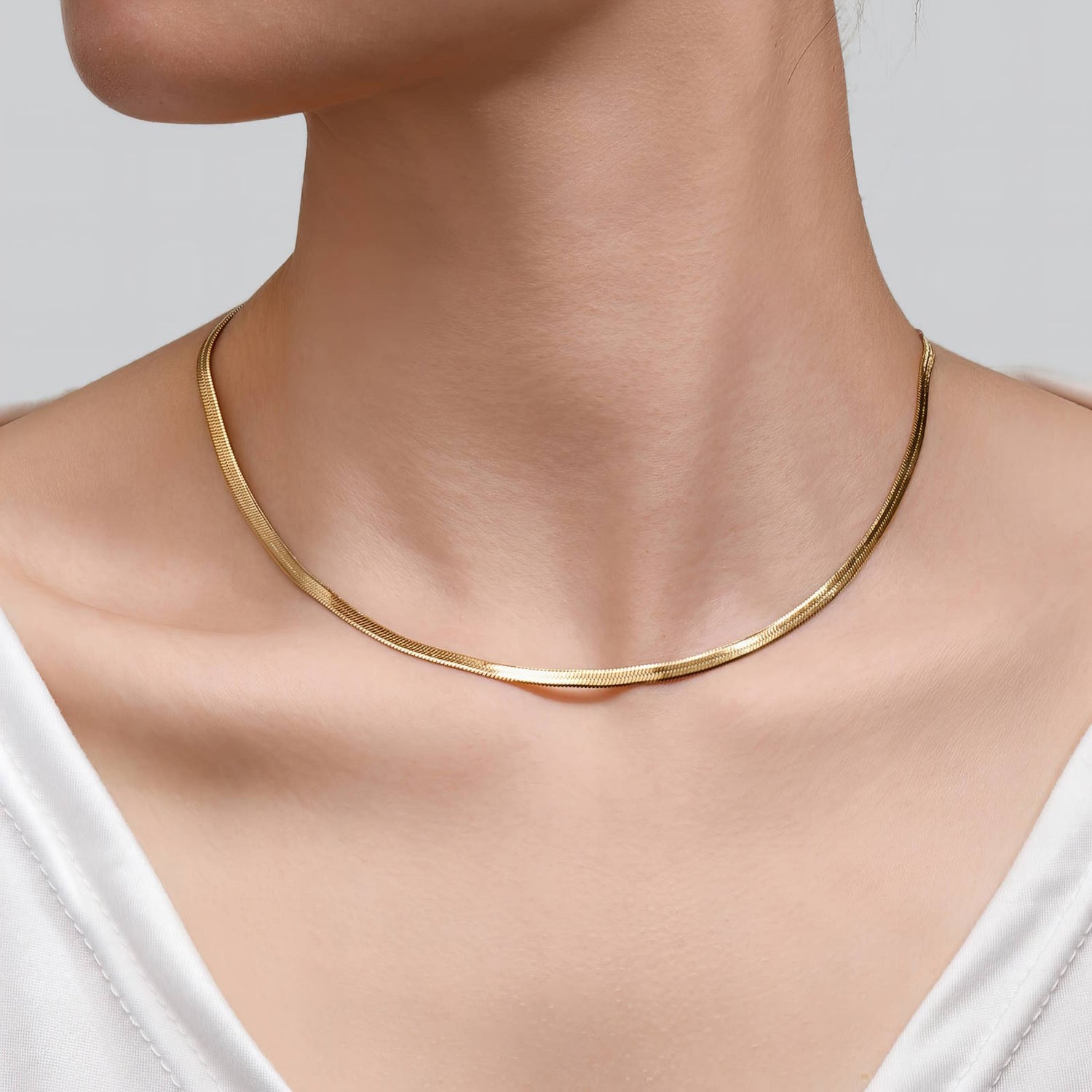 Close up 18k gold waterproof herringbone necklace on model